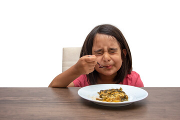Little girl is disgusted by tasting vegetable food