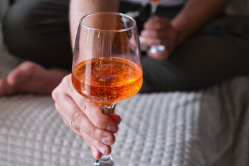 A glass of wine, aperol in the hands of a man resting at home Tasting alcoholic beverages. Romantic evening aperitif. Close-up of a glass of wine. Enjoy the moment