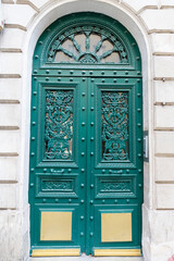 The rich decor decorates an entrance door of the old building of traditional architecture of in downtown, Paris.