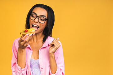 Black american african happy woman eating cake dessert isolated over yellow background. Eating cupcake. Diet unhealthy food concept.