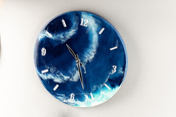 Round wall clock with ocean shore pattern. Vacation time concept. Time for rest and lunch. Luxurious epoxy resin accessories for the living room or lounge area. The concept of a minute of the Earth.