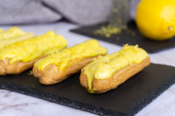 Eclair with custard and lemon glaze sprinkled with lemon zest.