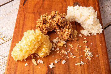 Cocada, Brazilian coconut-based candy arranged on a rustic wooden table, selective focus.