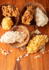 Cocada, Brazilian coconut-based candy arranged on a rustic wooden table, selective focus.