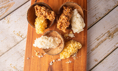 Cocada, Brazilian coconut-based candy arranged on a rustic wooden table, selective focus.
