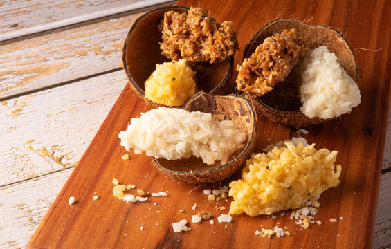Cocada, Brazilian coconut-based candy arranged on a rustic wooden table, selective focus.