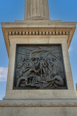 Fototapeta na wymiar London, UK- July 4, 2022: Trafalgar Square. Closeup of black mural sculpture set in white marble pedestal of Nelson's Column depicts scene of Battle of Cape St. Vincent in 1797