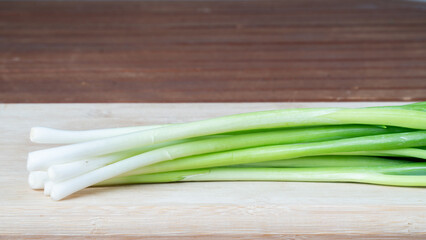 green onions feathers close-up on wooden board greenery