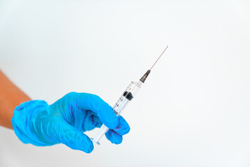women's hands in blue gloves with a disposable syringe. 