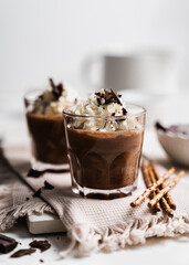 chocolate cake with coffee 
chocolate mousse cream in a glass cup on a white background with whipped cream and salty sticks snack snack sweet dessert