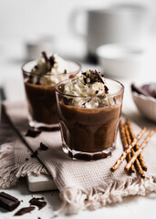 chocolate cake with coffee 
chocolate mousse cream in a glass cup on a white background with whipped cream and salty sticks snack snack sweet dessert