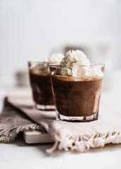 chocolate cake with coffee 
chocolate mousse cream in a glass cup on a white background with whipped cream and salty sticks snack snack sweet dessert