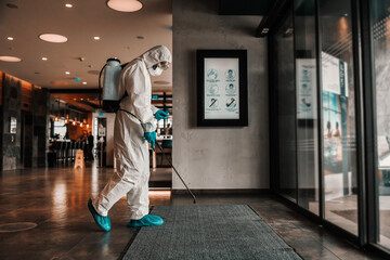The danger of corona. A man in protective clothing prevents the spread of the infection in a...