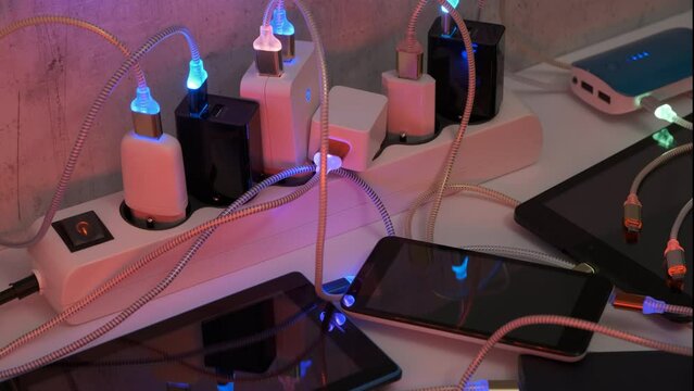 Connect Smartphone Mobile Phone and tablets connected to Charging hub on the Table, micro usb   wires to chargers in sockets with LED light Blinking. Extension cord switch loaded with Charger 