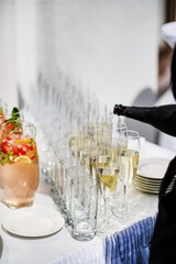 Stylish champagne glasses and food appetizers on table at wedding reception