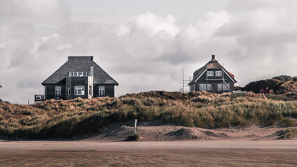Beach houses in Fanø Island under the cloudy sky - obrazy, fototapety, plakaty