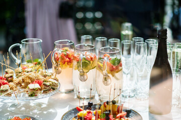 Stylish champagne glasses and food appetizers on table at wedding reception