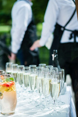 Stylish champagne glasses and food appetizers on table at wedding reception