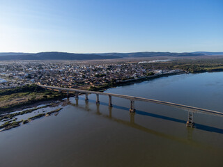 Beautiful bridge over the silver river in the morning sun on the edge of a small town in the...