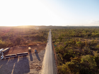 Extensive flat highway amid the undergrowth of the brazilian savannah with lots of greenery and sun...