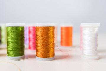 green, orange and white, close-ups of colored threads, dressmaker, atelier, seamstress, sewing...