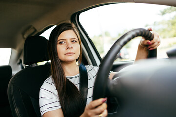 Obraz na płótnie Canvas Concentrated woman driving the car