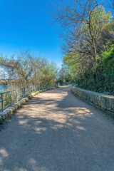 Flat dirt path with metal railings near the slope with concrete wall at Austin, Texas