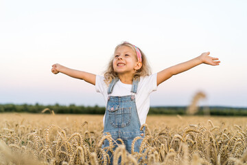 a little blonde curly girl running in a wheat field, the concept of human freedom