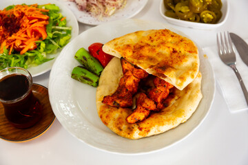 Turkish chicken shish kebab served on pita bread with vegetable garnish. Dish of authentic cuisine