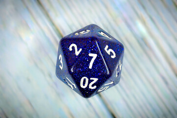 Lucky number seven on a sparkly blue twenty-sided adventure game die.