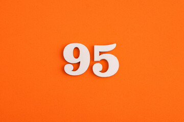 White wooden number 95 on eva rubber orange background