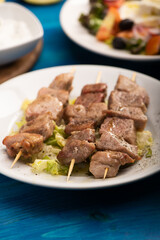 A grilled pork souvlaki served with greek salad
