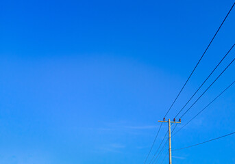 electric pole in a minimalist composition on a bright blue sky with empty space to enter text