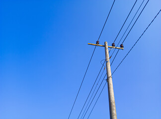 electric pole in a minimalist composition on a bright blue sky with empty space to enter text