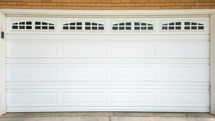 Panorama White sectional garage door with window panels and concrete driveway