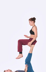 Young athletic couple practicing acroyoga. Balancing in pair