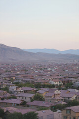 Zoomed out panoramic view of master planned community consisting of single family homes in a major metropolitan city suburb within the desert southwest after sunset with mountains and colorful sky