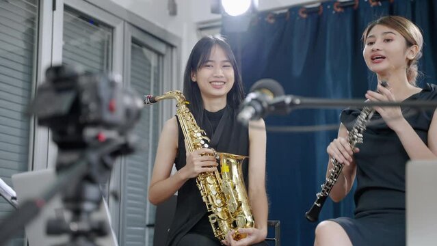 Asian female orchestra is streaming live online via camera.
