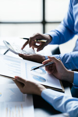 Business team reviewing a diagram or chart and financial reports for a return on investment or...