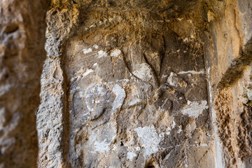Closeup of reliefs carved in stone cliff near ancient Lycian rock tombs in Tlos city, Mugla Province, Turkey