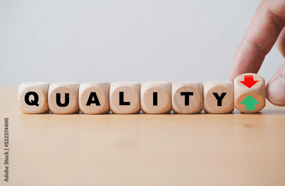 Fototapete Hand flipping between green up arrow and red down arrow with quality wording for product and service increase and decrease quality concept.