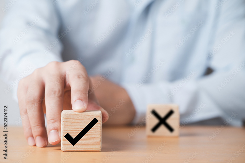 Aufkleber Hand pushing tick correct sign mark in front of cross mark for approve document and project concept.