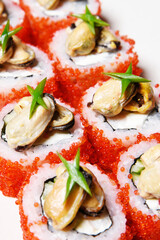 Elite sushi on a white background in red tobiko caviar with mussels on top. Food
