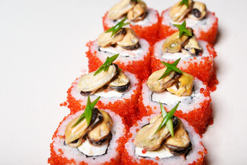 Elite sushi on a white background in red tobiko caviar with mussels on top. Food