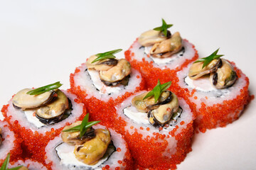 Elite sushi on a white background in red tobiko caviar with mussels on top. Food