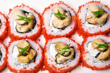 Elite sushi on a white background in red tobiko caviar with mussels on top. Food