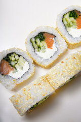 Sushi on a white background in sesame. Philadelphia with cucumber roll. Food.