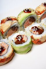 Sushi on a white background in sesame seeds with avocado and nigiri. Philadelphia with salmon roll. Food.