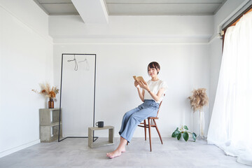 シンプルな部屋で本を読む女性