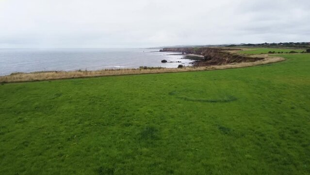 Drone shot flying over cliff on coast of England with the North Sea